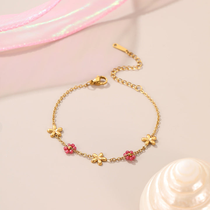 Bracelet Birdy, fleurs roses émaillées sur double chaîne dorée